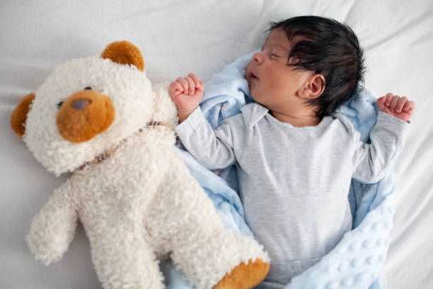 African American Newborn Baby Sleeping On A White Mattress