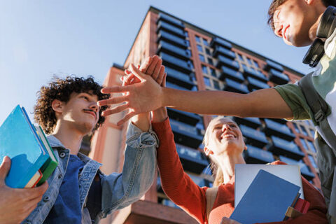 Diverse Group Of Students Putting Their Hands Together In A Circle