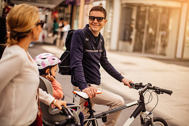 Photo Of Young Man Enjoying The Bicycle Ride With His Family Through The City
